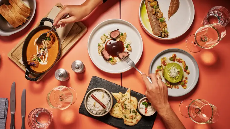 Ein Tisch von oben fotografiert mit vielen Tellern und Gerichten.