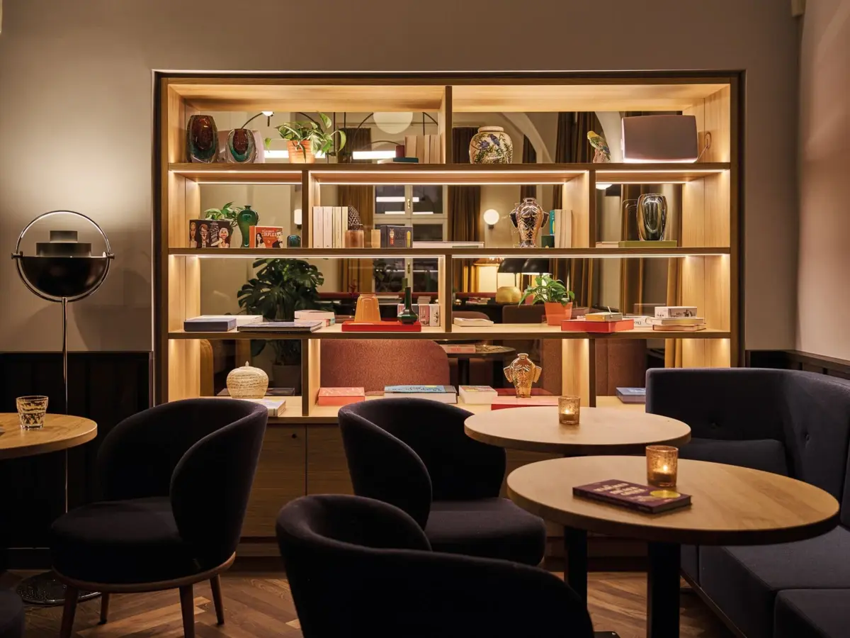 Separee in der Schlossbar im Badeschloss Bad Gastein Stilvoller Lounge-Bereich im Urban Nature Hotel Bad Gastein mit Regal, Vasen, Kerzenlicht und gemütlichen Sesseln