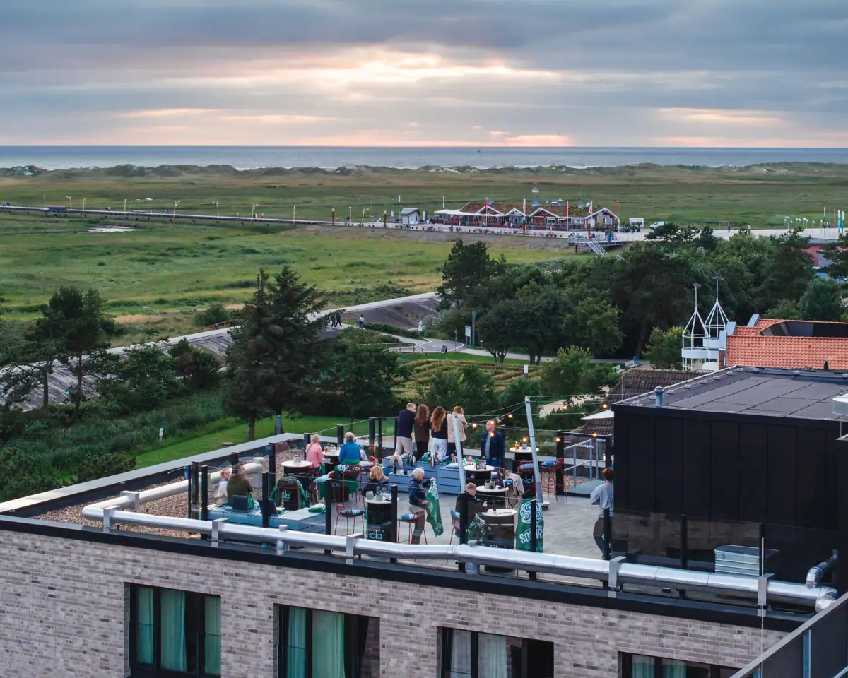 Eine Gruppe von Menschen in der Rooftopbar vom Urban Nature Hotel St. Peter-Ording.