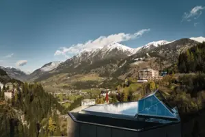 Ein Gebäude mit Glasdach vor einer Bergkette.