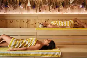 Frau liegt auf einer Bank in einer Sauna.