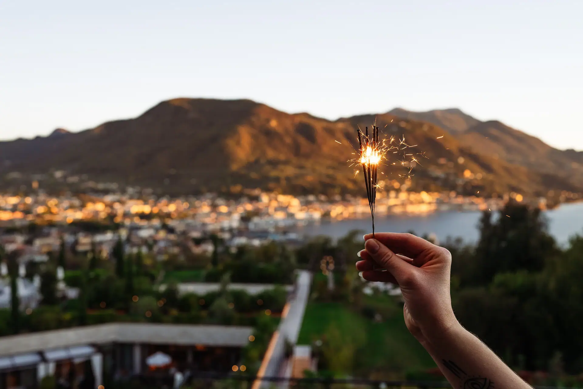 Eine Person hält eine Wunderkerze vor einem Berg.