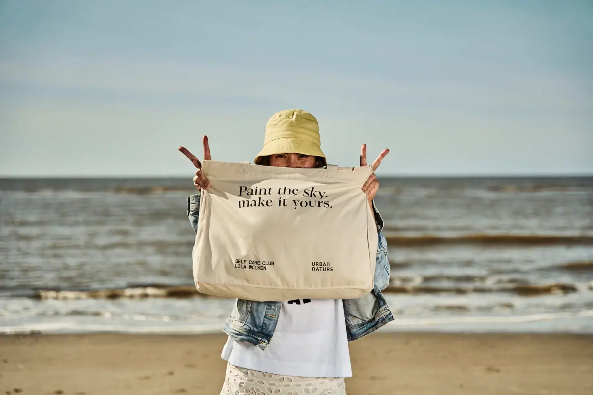 Sommerurlaub 2026 St. Peter-Ording Eine Frau hält eine Tasche am Strand.