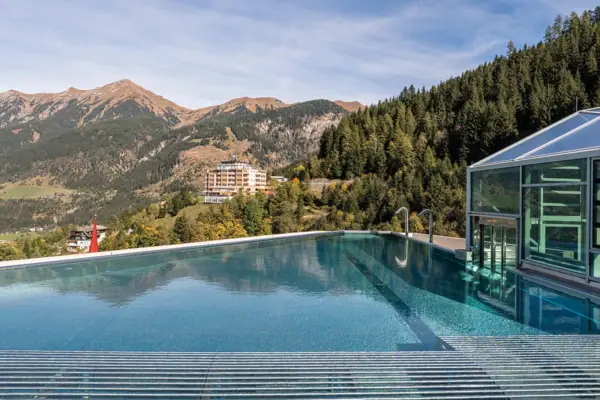 Pool mit Gebäude und Bergen im Hintergrund