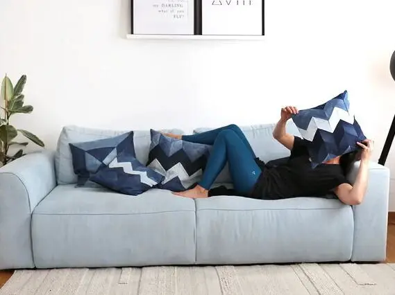 Bridge and Tunnel Eine Frau liegt auf einem Sofa mit Kissen.